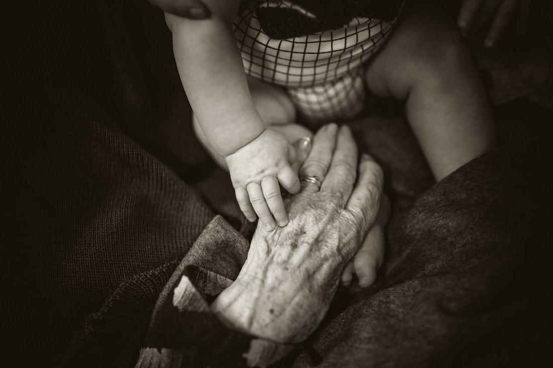 Kinderhand und Hand eines alten Menschen – Symbolbild